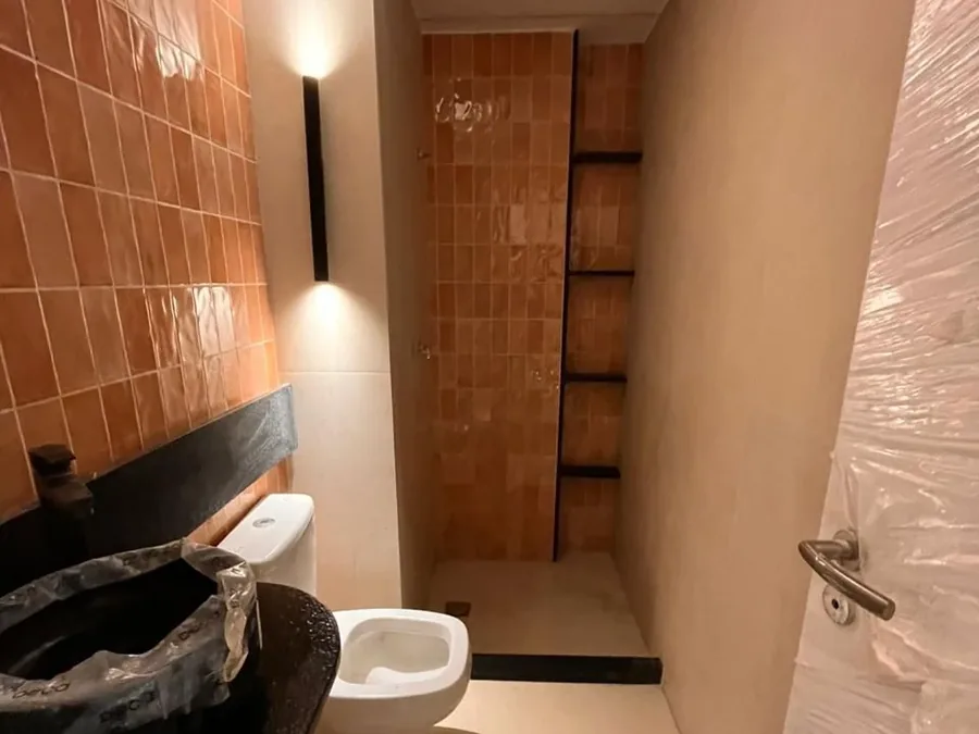 Banheiro reformado com bancada em pedra e nicho no box, obra da Apto Engenharia no Recreio dos Bandeirantes
